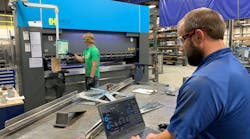 Dave Smit, senior systems analyst at Interstates (right), examines the network traffic dashboard and communication settings in Veracity OT Network Controller software at the system integrator&rsquo;s prefabrication shop in Sioux Center, Iowa, while Jace Mulder, production technician (left), operates the Haco press break. OT Network Controller manages a software-defined network (SDN) switch from Dynics, and uses zero-trust and deny-by-default methods, which enables Interstates to improve network visibility and security for the machine and enhance operational efficiency. Source: Interstates